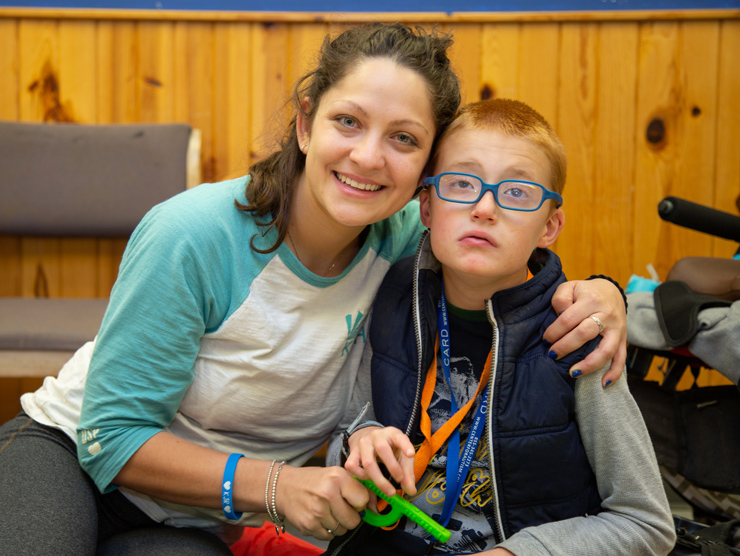 A boy and his counselor smiling at camp.