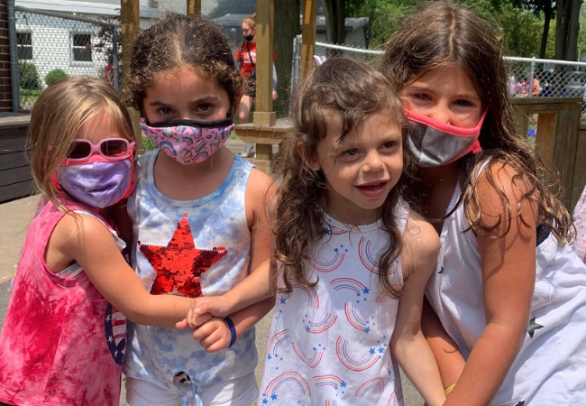 A group of girls hugging one another at "Z" Frank Apachi Day Camp.