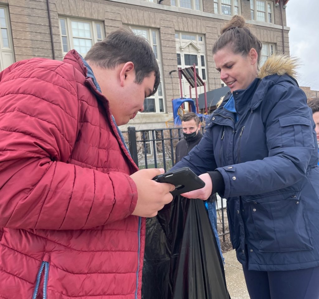 Two individuals holding a trash bag at the North Lawndale community clean-up