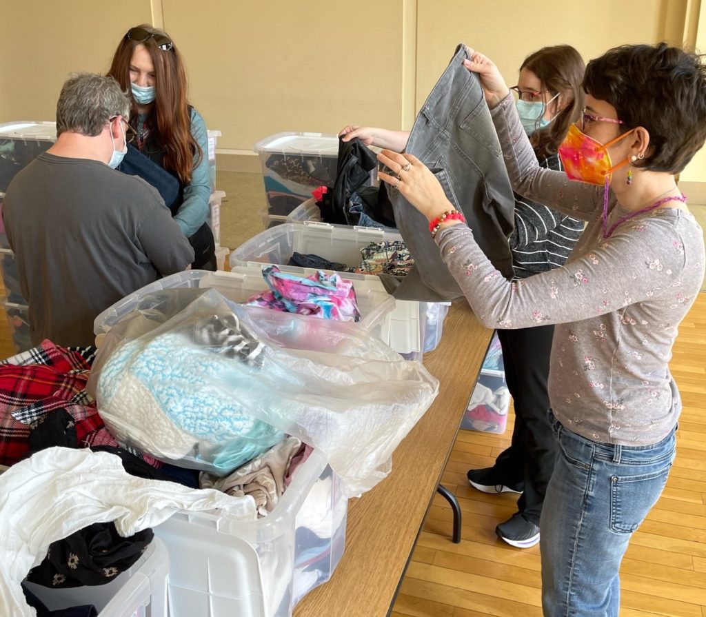 MY Life participants sorting through and packaging clothes at Cradles to Crayons