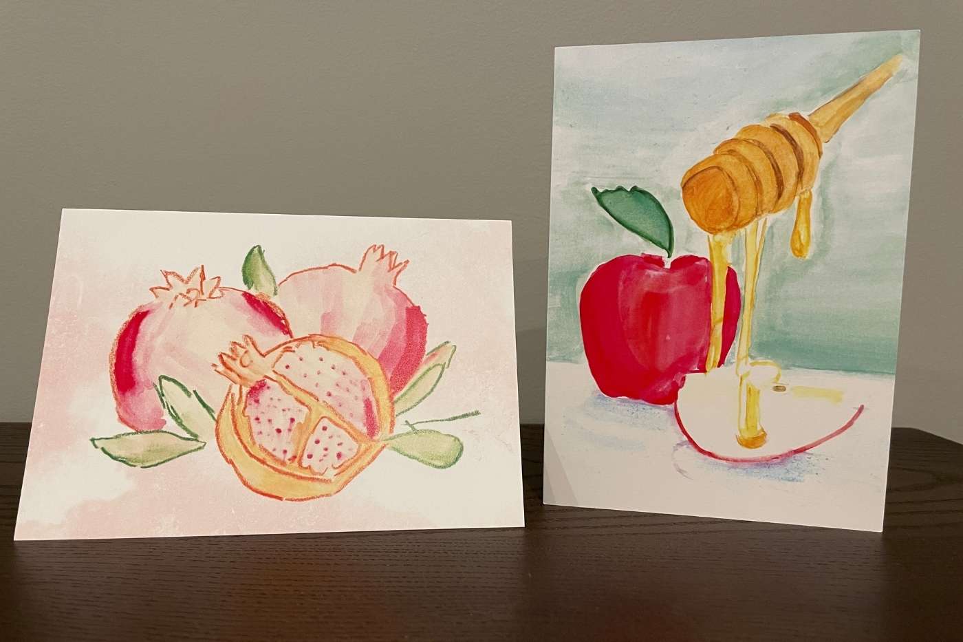2 styles of Rosh Hashanah cards, one features a pomegranate and the other has apples with honey