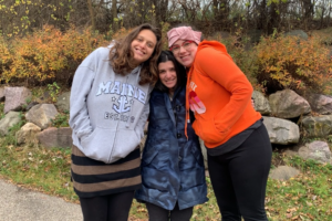 Rachel hugging two friends outside at the Shabbaton