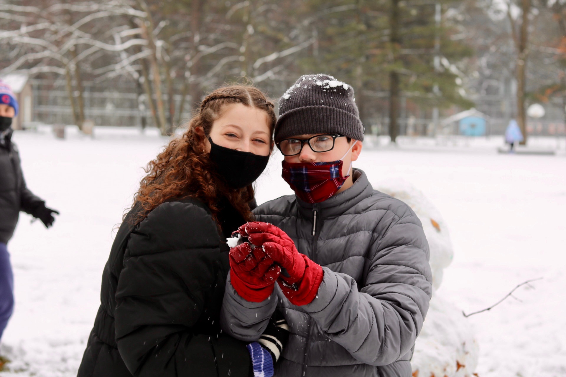 Staff member and winter camper outside in the snow together