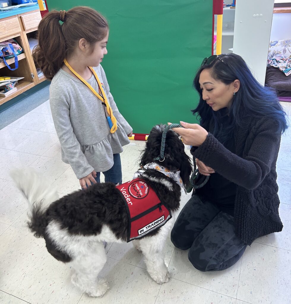 Therapist helping student pet Vader, the therapy dog