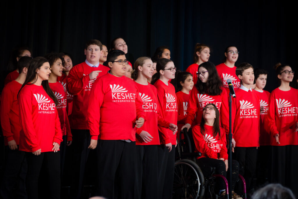 Keshet Choir in their red shirts from the 2019 concert on stage