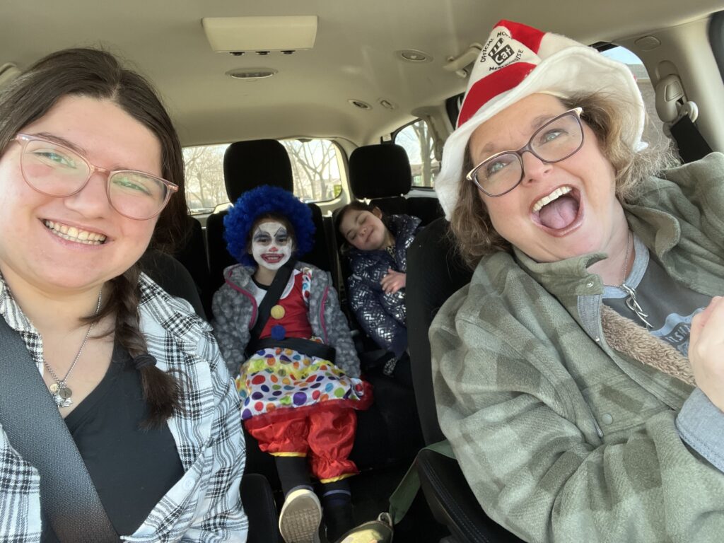 Selfie of Sunday School staff and students in their car and in costumes on the way to the Purim Party
