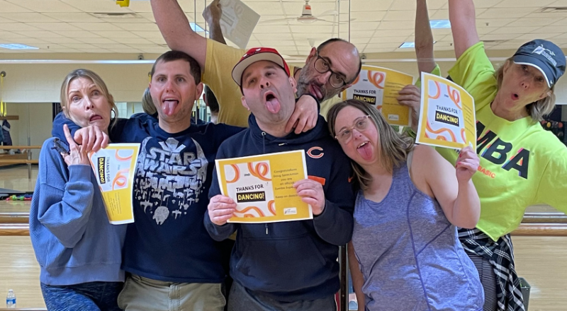 Zumba instructors and participants holding up certificates and making silly faces