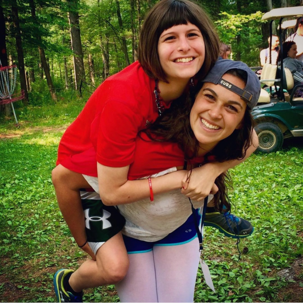 Jackie giving her friend a piggy back ride at camp