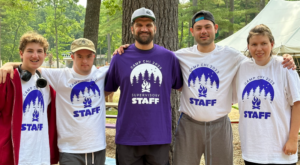 Five camp chi staff in their staff shirts with their arms around each other