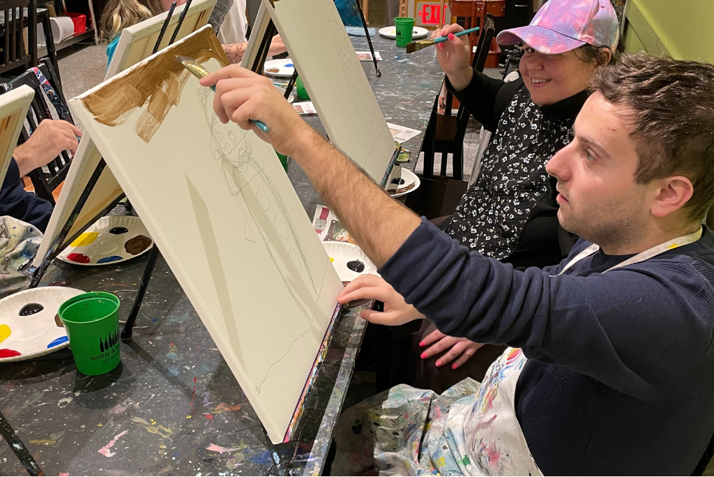 Adult painting a canvas