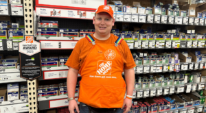 Luke in his Home Depot uniform standing in the aisle