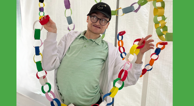 Keshet adult holding a long Sukkot paper chain