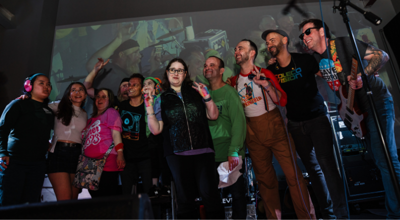 Samara on stage with performers at the Keshet Concert