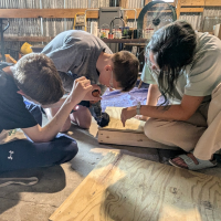 Avodah team member using a drill and two people watching