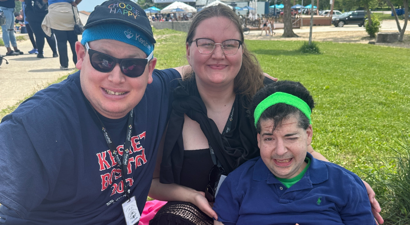 Ashley smiling with two keshet participants at the beach