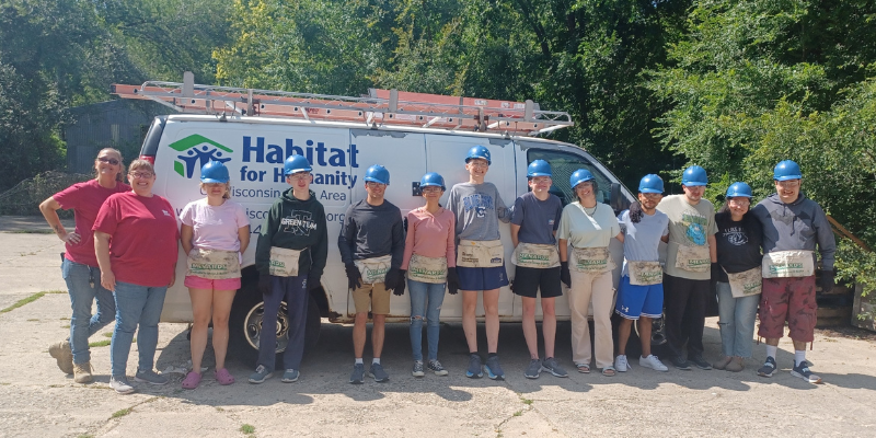 Avodah team members and other volunteers standing in front of a Habitat for Humanity van