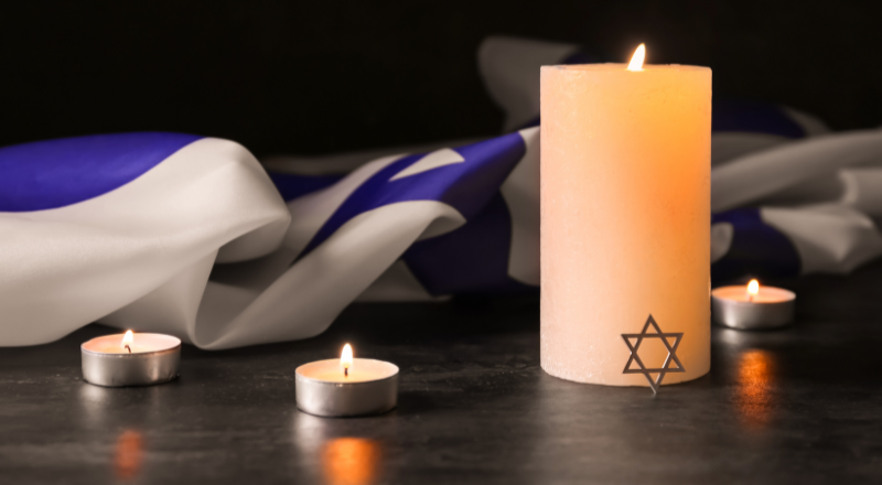 Israeli flag next to a memorial candle with a jewish star