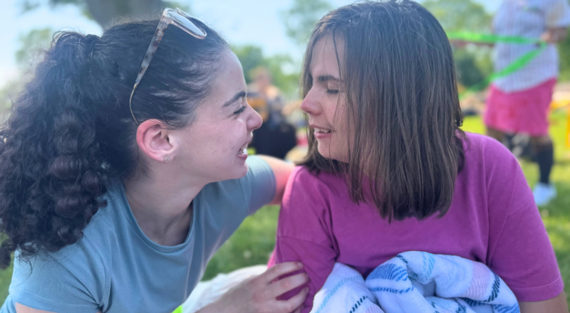 Camper and counselor looking at each other and smiling