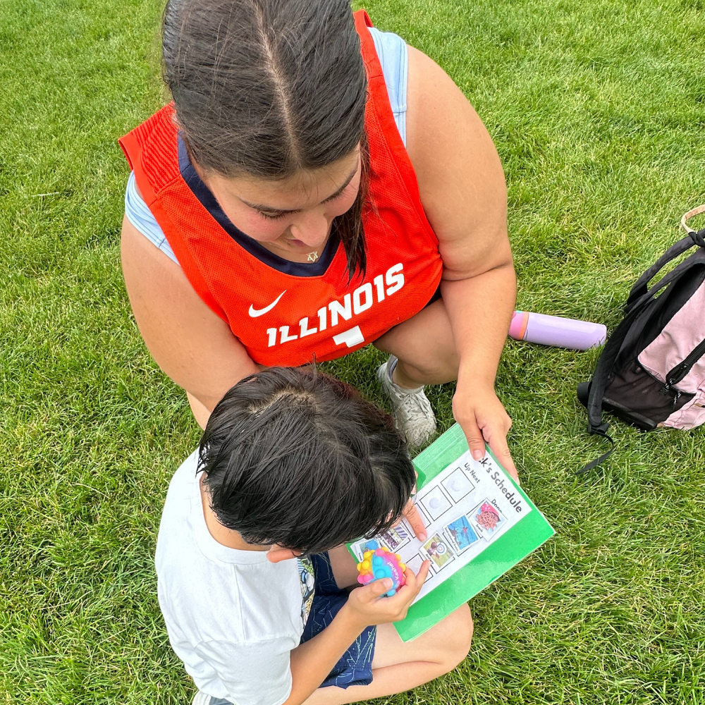 camper and counselor reading a schedule together