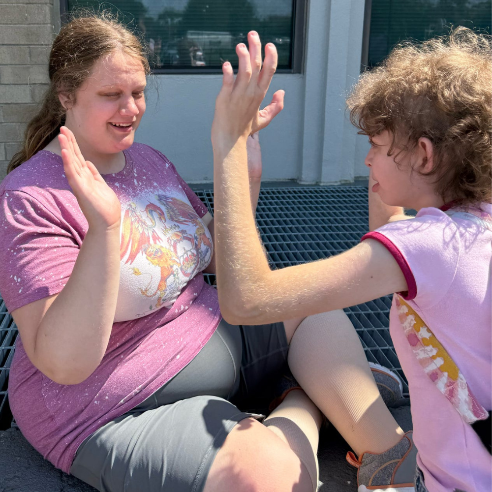 Two campers high fiving and smiling at each other