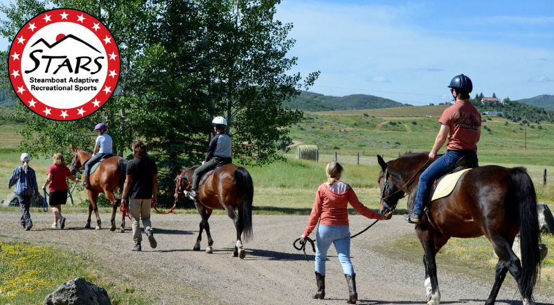 Adults horseback riding with the STARS logo
