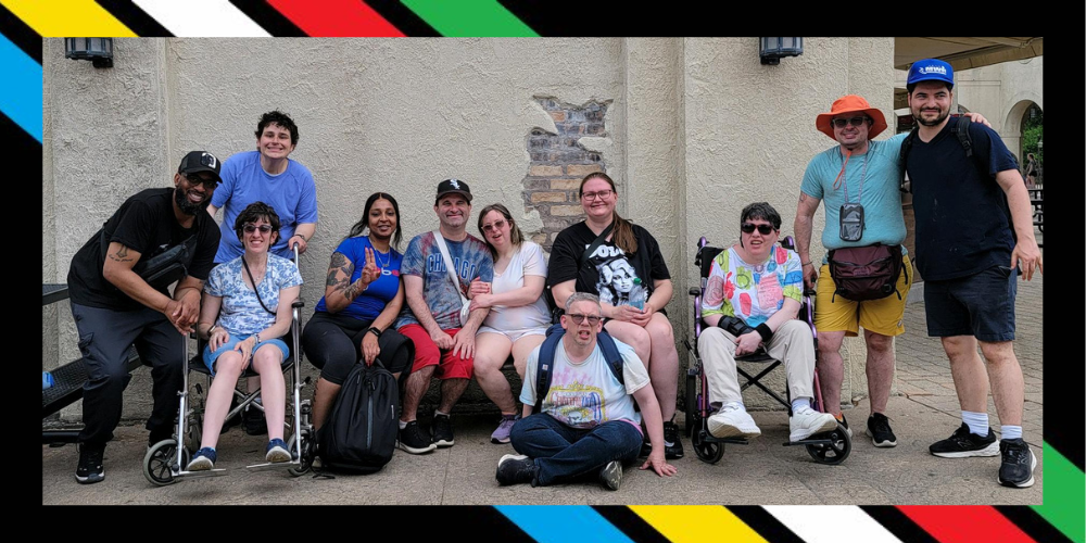 Disability pride flag overlayed with a picture of Group of Keshet adults and staff at Six Flags
