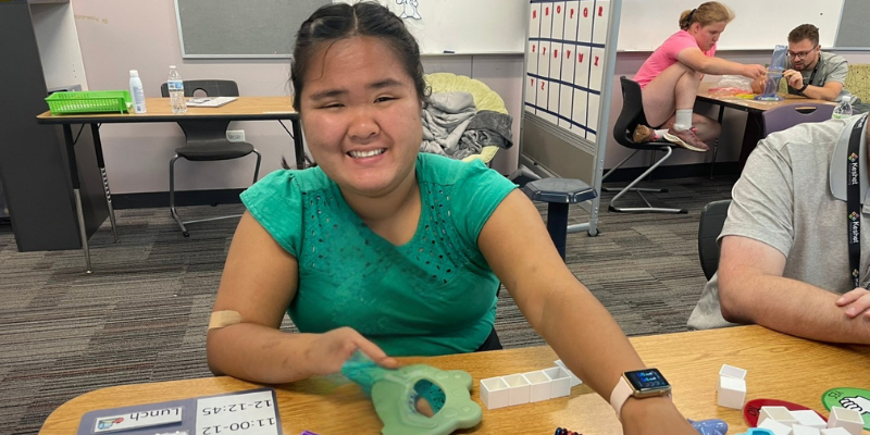 Student smiling while sitting at a desk
