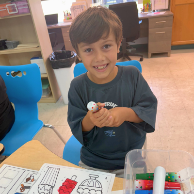 Student smiling and holding a dot marker