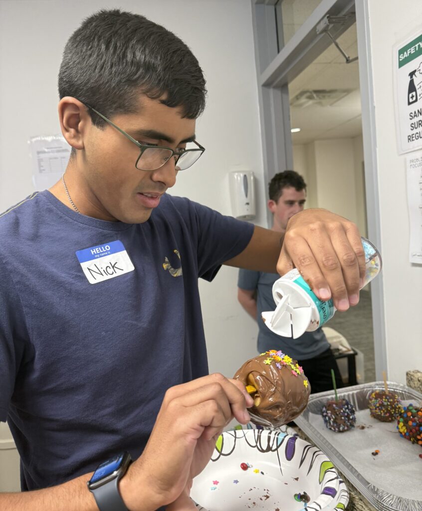 Adult decorating a toffee apple