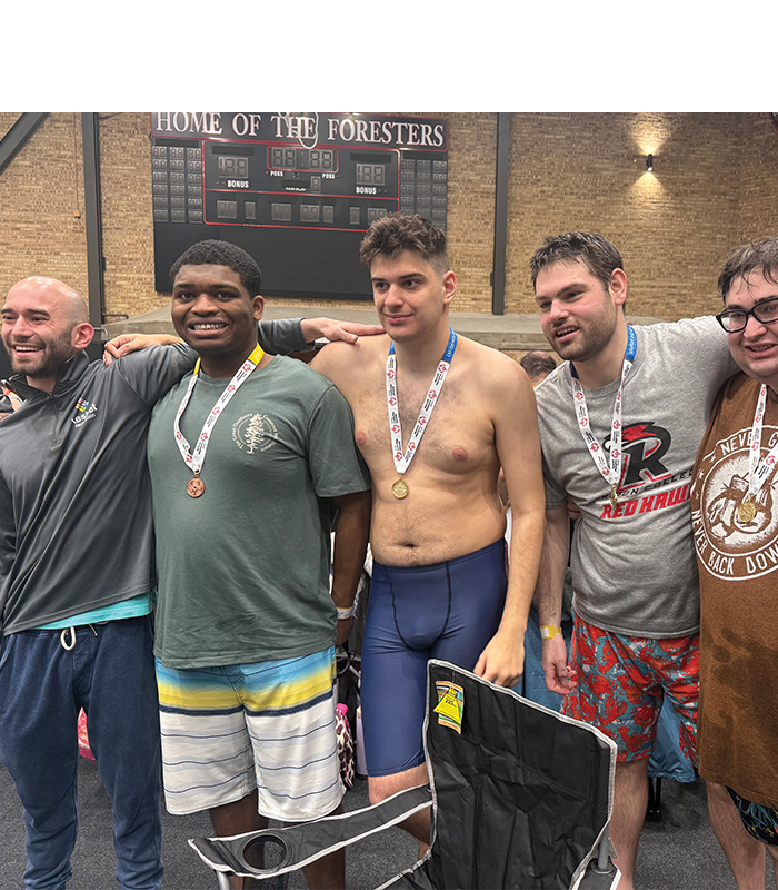 Group of Keshet swimmers standing together and wearing their medals