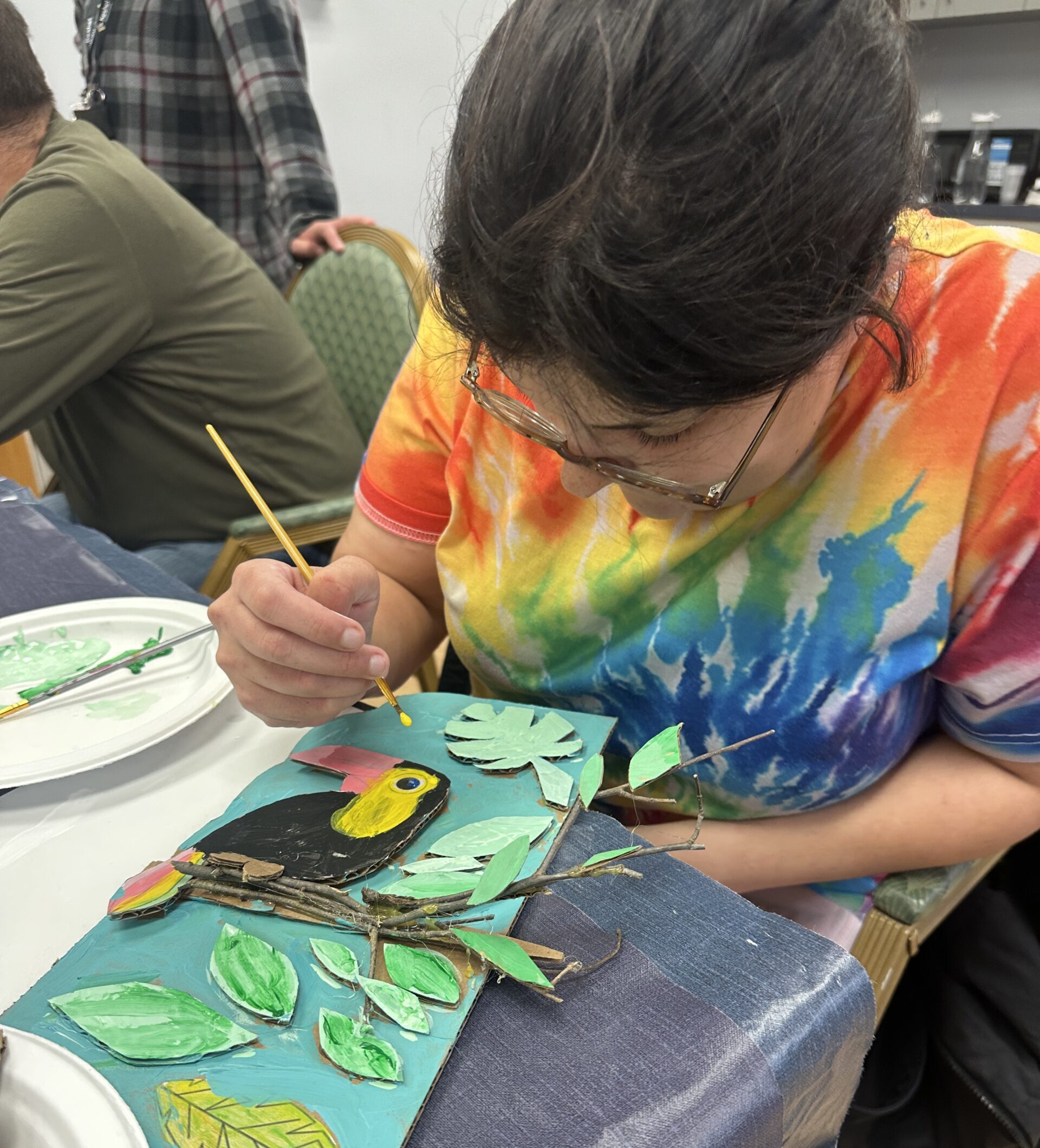 Team member painting a 3d toucan