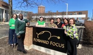 Group of doctors standing with the forward focus sign outside of the building