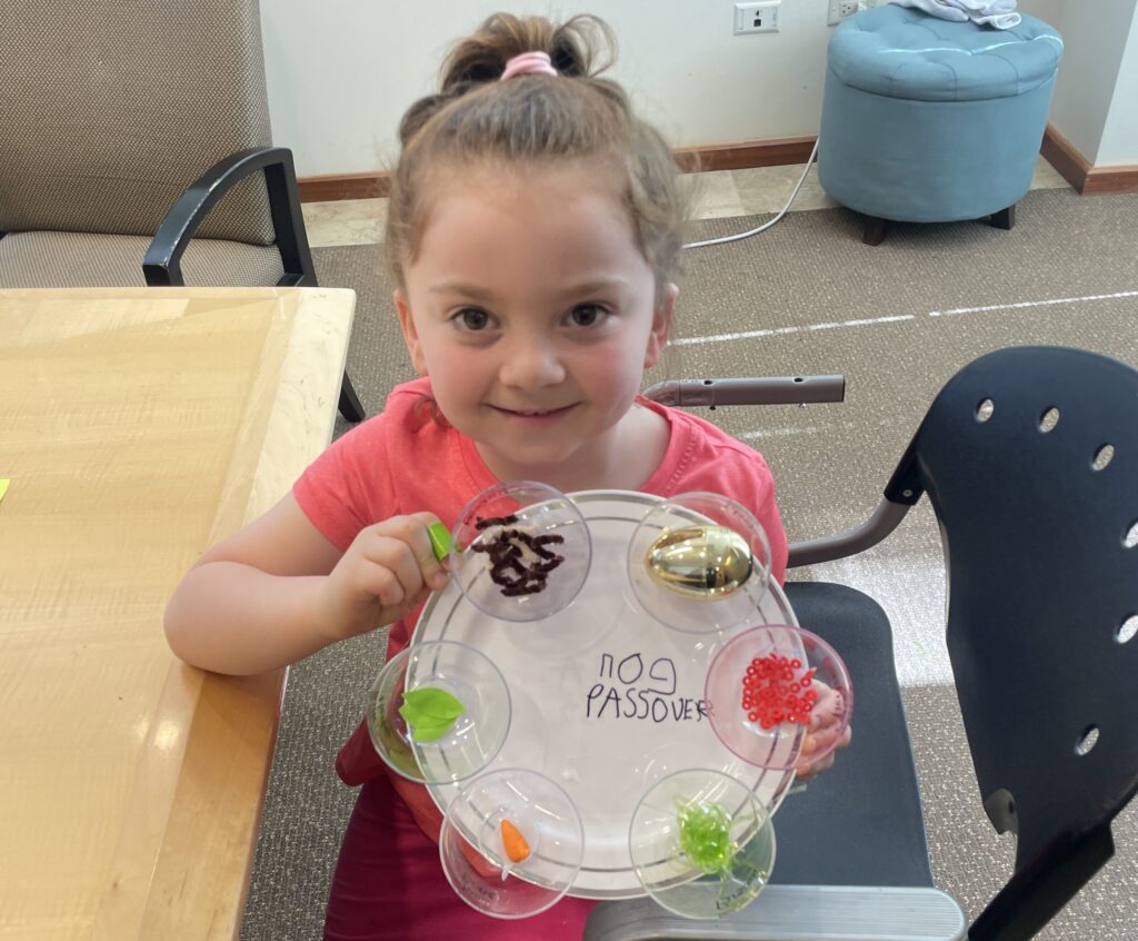 Student smiling while holding their sensory seder plate