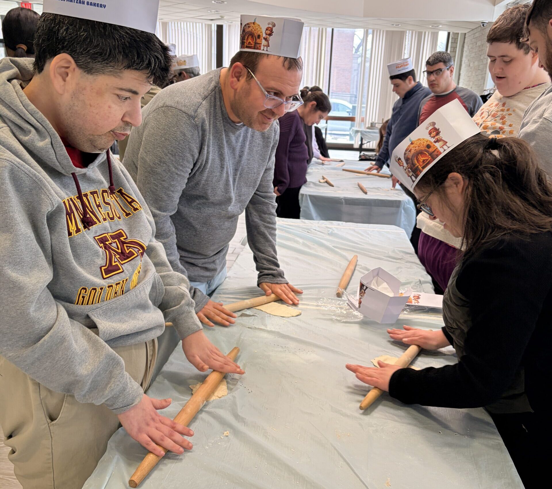 Adults rolling matzah dough