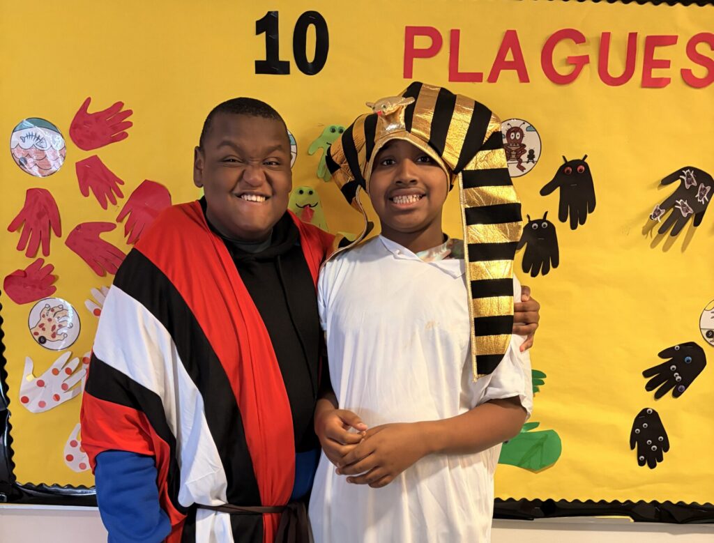 Two students in Pharoah and Moses costumes with their arms around each other
