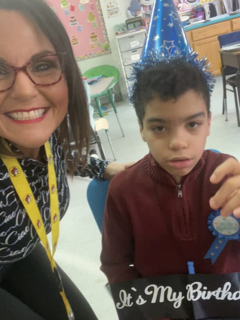 selfie of elaine with a student wearing a party hat for their birthday