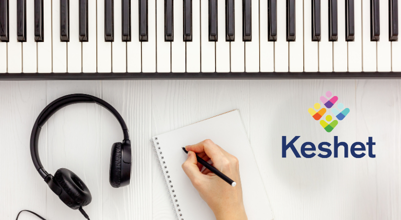 Table with piano, headphones, pen and paper and the Keshet logo