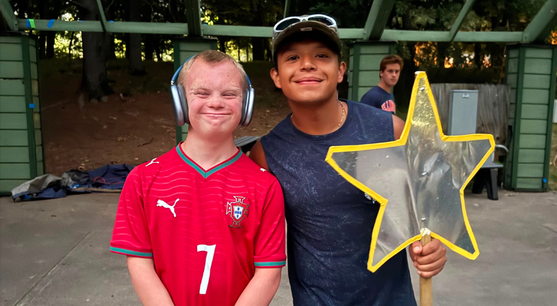Mauricio with a camper, holding a staff star award