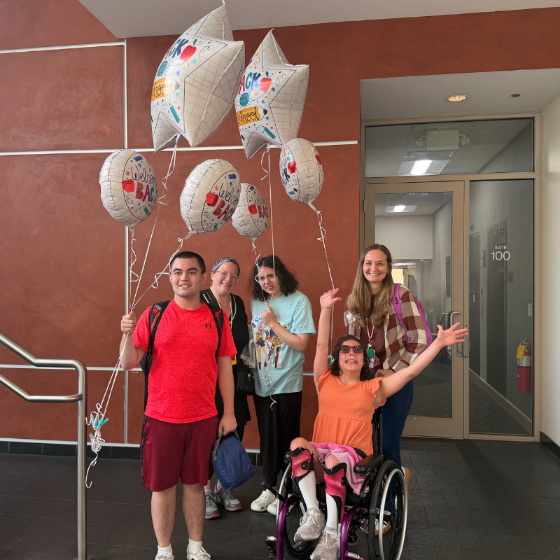 students and staff with welcome back to school balloons